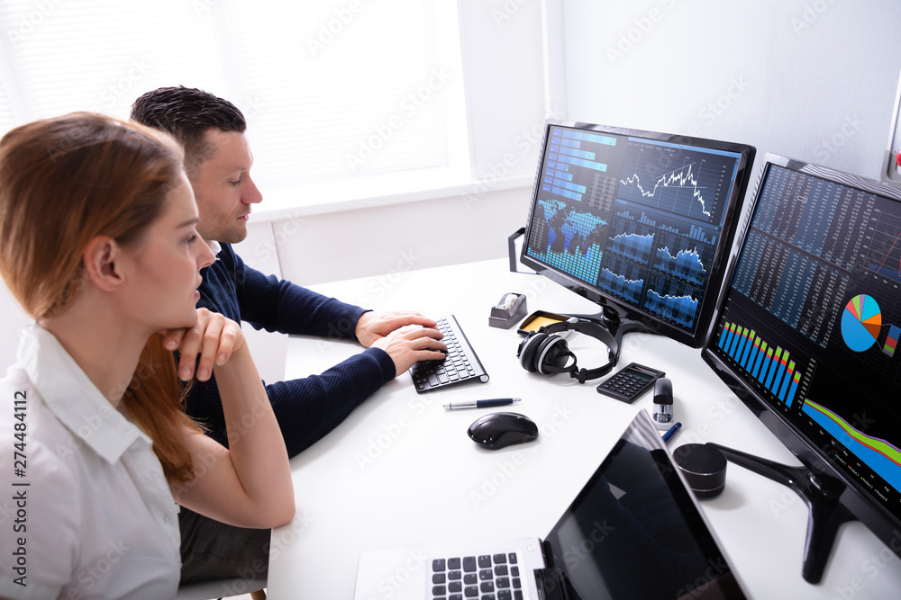 Poster two businesspeople examining graph on computer