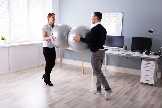 Professional Man And Woman Holding Fitness Ball