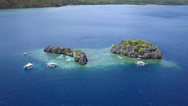 Aerial view of small rocky islands with  boats surrounded by turquoise sea. Palawan May 2017. Trucking shot
