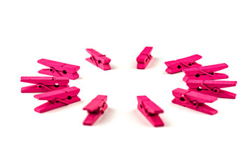 Fototapeta premium Pink wooden clothespins isolated on white background arranged in a circle
