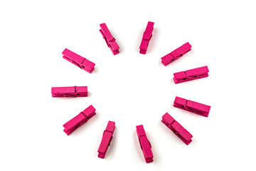 Pink wooden clothespins isolated on white background arranged in a circle