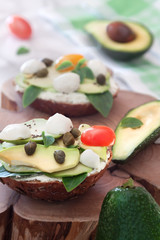 Homemade avocado sandwich with fresh sliced avocados, mozzarella and vegetables. Healthy breakfast for gourmet snackables