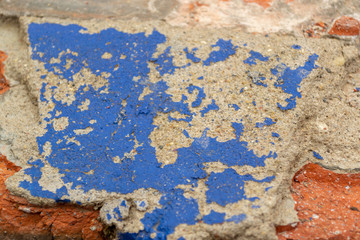 Chipped concrete surface with blue paint coming off
