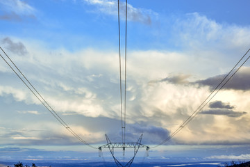 Electric tower in blue sky with clouds at sunset