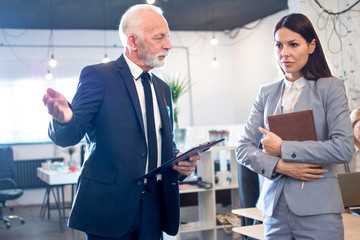 Angry senior man boss firing unprofessional female employee with hand gesture