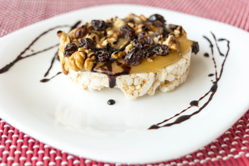  Rice biscuit with honey, nuts and raisins without seeds bathed in light chocolate threads.