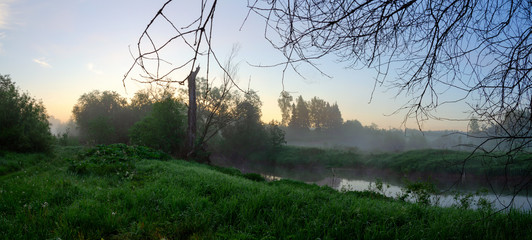 Serene foggy summer panoramic landscape with  forest river  at sunrise.