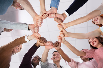 Low Angle View Of People Making Circle With Their Hands