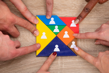 Group Of People's Hand On Colorful Tangram Puzzle Blocks