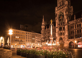 Fototapeta na wymiar Munich Germany, New Town Hall , Rathaus at the Marienplatz seen at night with spring tulips in bloom