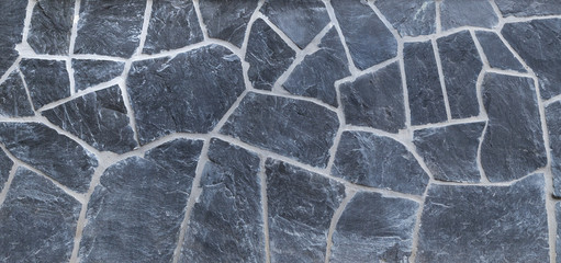 High resolution full frame background of a wall made of old and weathered gray stone slates. Copy space.