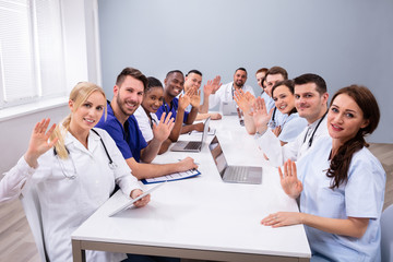 Doctors Waving Their Hands In Conference Room