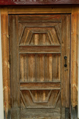 Obraz premium Old wooden brown door with metal handles. door in the street in the old house