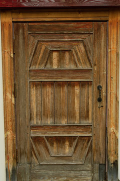 Old wooden brown door with metal handles. door in the street in the old house