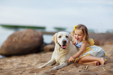 Little girl with a labrador dog, outdoor summer