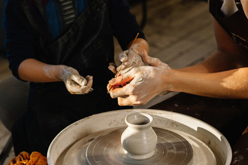 Professions Ideas. Woman potter teaching the art of pot making. Child working on potters wheel...