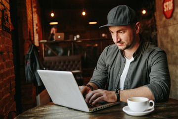 young man  working in cafe and drink black coffee