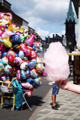 Obraz premium amusement park eating white cotton candy. enjoying a day at amusement park with fresh cotton candy in hand