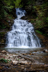 Obraz premium Beautiful waterfall between rocks in a mountain forest