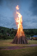 Feuer zur Sonnenwende auf Wiese mit Partyzelt