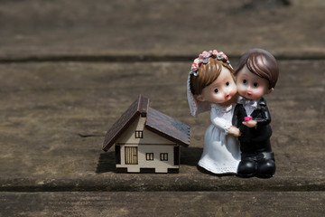real estate and mortgage investment. little house , bride and groom on the wooden background. Being an easy way homeowner.  