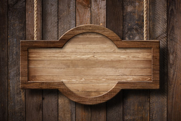 Wooden sign with rounded shape hanging on ropes with wood planks background