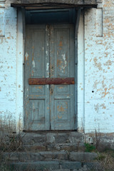 The boarded up door of the facade wall of the nineteenth century building.