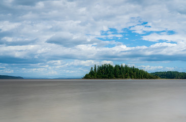 Island Under Blue Skies and Clouds Along Puget Sound, Washington State, USA