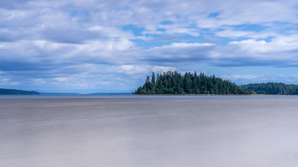Island Under Blue Skies and Clouds Along Puget Sound, Washington State, USA