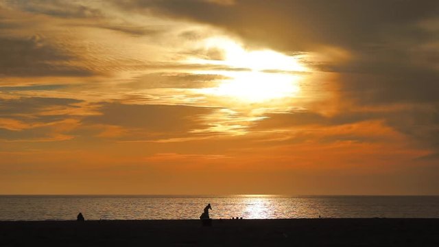 VENICE BEACH, SANTA MONICA, LOS ANGELES, CA. People walk along the beach in sunset light. Golden hour at Venice Beach.