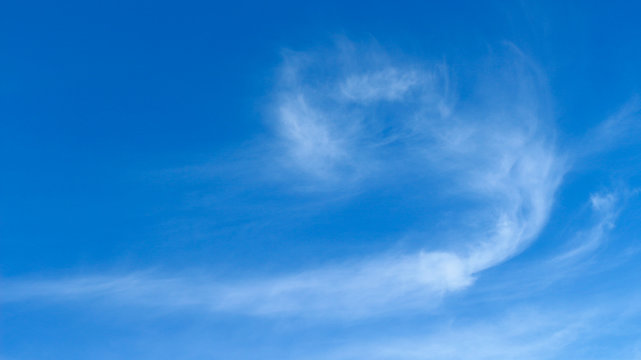 Long cirrus clouds on blue sky