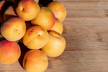 Naklejka na ściany i meble Close up of ripe Blenheim apricots freshly picked, on a wooden table, California