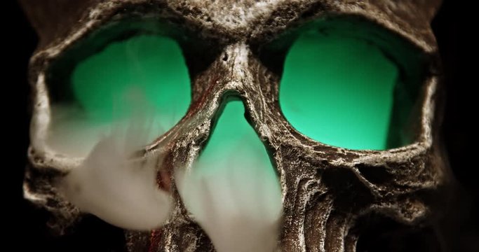 Smoking Skull with a green Glow tightly framed over the eyes and nose, no audio