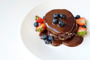 Pancakes with chocolate and blueberry on the top; healthy summer breakfast
