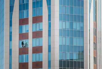 Window washer in skyscrapers. Industrial alpinism. Unusual work.