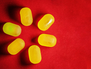 yellow jelly candies are close-up laid out in a circle on a red background