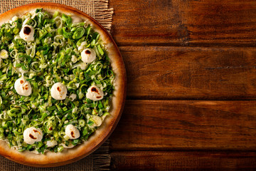 Fototapeta na wymiar Pizza leek and cream cheese on wood background. Top view, close up. Traditional Brazilian Pizza