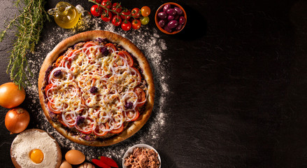 Pizza tuna fish, onion, tomato and black olive on wood background. Top view, close up. Traditional Brazilian Pizza
