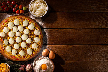 Pizza corn and cheese on wood background. Top view, close up. Traditional Brazilian Pizza.