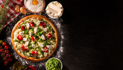 Various vegetables at wooden rustic background with copyspace on round pizza desk. Set of fresh vegetables. Egg, tomatoes, pepper, lettuce, onion, garlic, onion. Pizza ingredients.