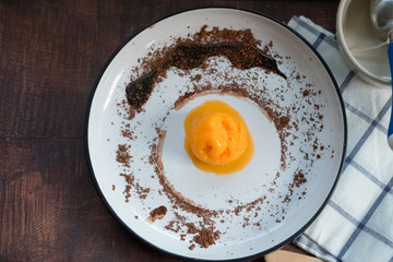 Scoop of passion fruit flavor ice cream with chocolate powder