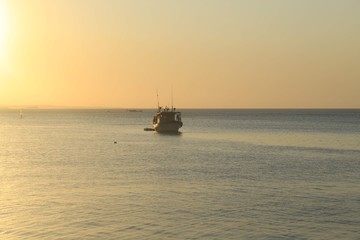 Obraz premium fishing boat at sunset