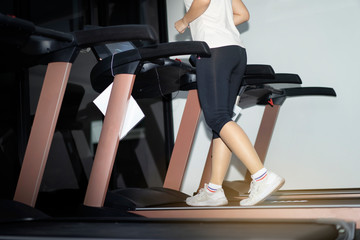 Fototapeta na wymiar Concept of fitness.Woman running on treadmill in fitness.woman doing cardio training with treadmill