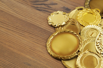 Gold medals with ribbons on wooden table with space for text