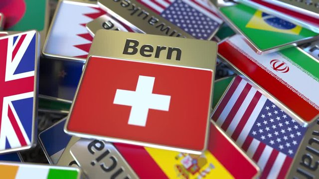 Souvenir magnet or badge with Bern text and national flag among different ones. Traveling to Switzerland conceptual intro animation