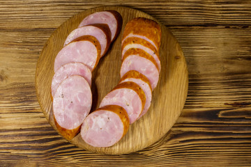 Sliced smoked sausage on cutting board on wooden table