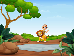 Happy zookeeper boy and lion near the small pond