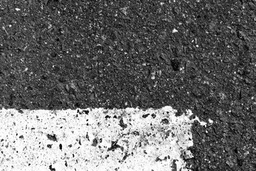 Asphalt surface with old paint on it close up. Abstract background black and white