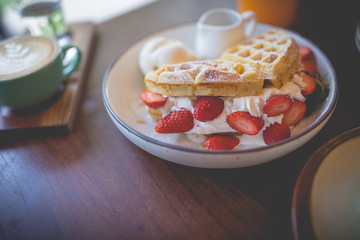 waffle pancake desert with vanilla ice cream, fresh strawberry and honey syrup