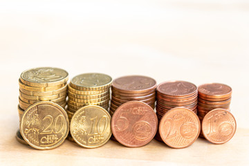 Mehrere Stapel mit EURO-Münzen zeugen von fleißigem Sparen und dem Ersparten eines Kindes